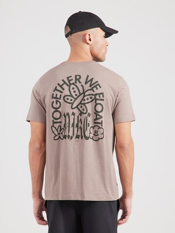 T-Shirt 'WE FLOAT' Nike Sportswear en marron : devant