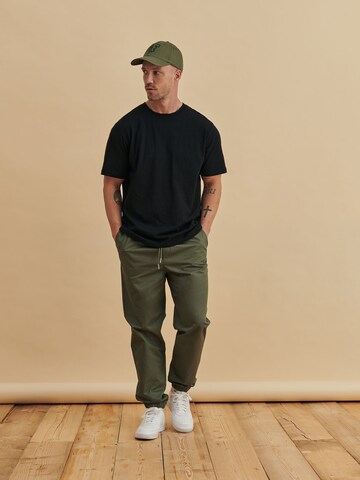 DAN FOX APPAREL Tapered Housut 'Julian' värissä vihreä