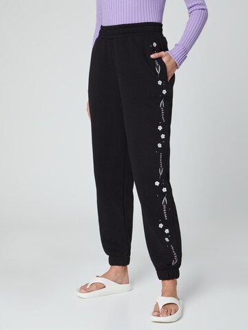 florence by mills exclusive for ABOUT YOU Tapered Trousers 'Lilli' in Black: front