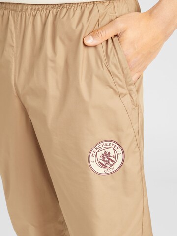 PUMA Zwężany krój Spodnie sportowe 'MCFC Prematch' w kolorze beżowy