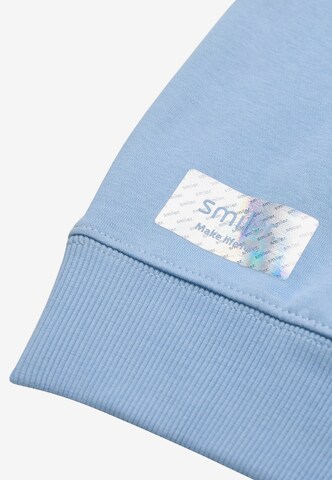 Sweat 'Happy' smiler. en bleu