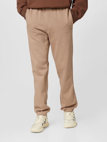 ADIDAS ORIGINALS Zwężany krój Spodnie 'Reveal Essentials' w kolorze brązowy: przód