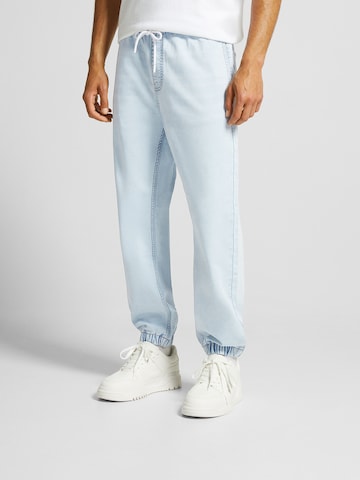 Bershka Tapered Jeans in Blue: front