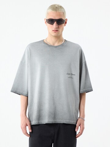 VAMOS CLO T-shirt 'The Colony' i grå: framsida