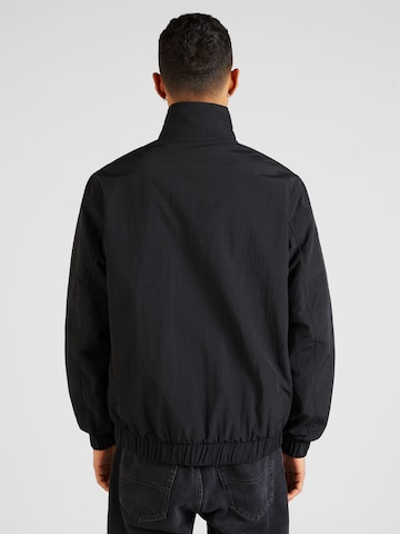 Tommy Jeans Overgangsjakke 'ESSENTIAL' i svart