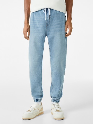 Bershka Tapered Jeans in Blue: front