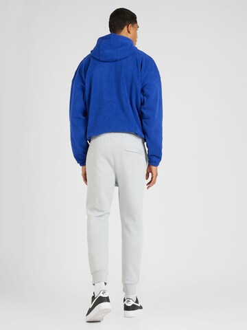 Nike Sportswear Tapered Housut 'Club Fleece' värissä valkoinen