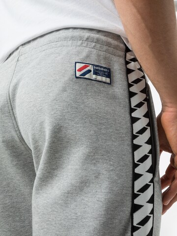 Superdry Tapered Urheiluhousut 'Code' värissä harmaa