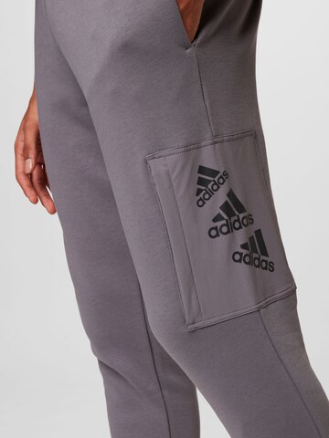 pilka ADIDAS SPORTSWEAR Siaurėjantis Sportinės kelnės 'Essentials Brandlove Fleece'