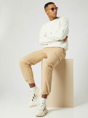 Regular Pantalon cargo Kosta Williams x About You en beige