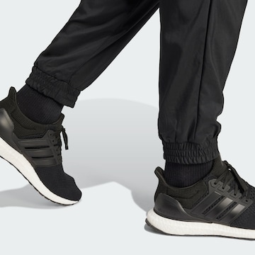 ADIDAS SPORTSWEAR Zwężany krój Spodnie sportowe 'Essentials' w kolorze czarny