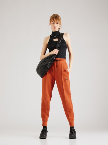 Nike Sportswear Zúžený Kalhoty 'TCH FLC' – oranžová