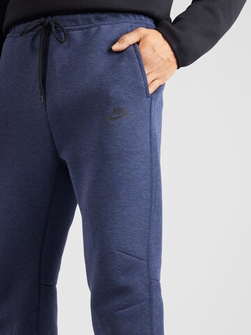 mėlyna Nike Sportswear Siaurėjantis Kelnės 'TECH FLEECE'