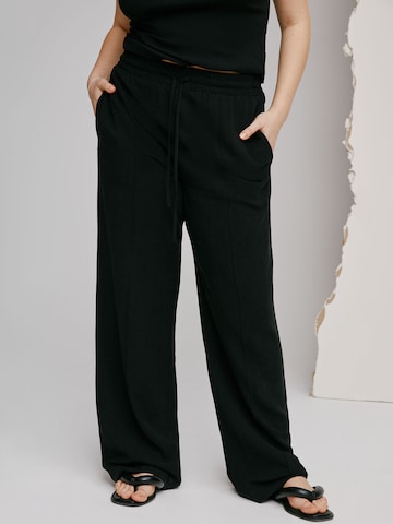 A LOT LESS גזרה משוחררת מכנסים קפלים 'Giovanna' בשחור: מלפנים