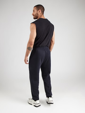UNDER ARMOUR - Tapered Pantalón deportivo en negro