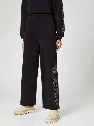 Hoermanseder x About You Wide leg Trousers in Black: front