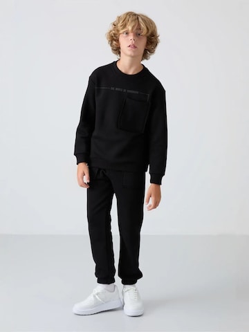 Tommy Life Trainingspak 'TOMMY Kinder Active Set' in Zwart: voorkant