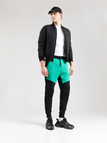 Tapered Pantaloni 'TCH FLC' de la Nike Sportswear pe negru