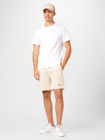 Karl Kani Regular Trousers in Beige