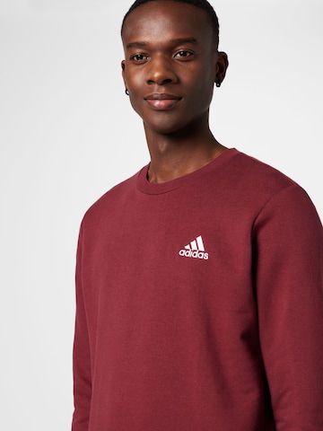 ADIDAS SPORTSWEAR - Sweatshirt de desporto 'Essentials' em vermelho