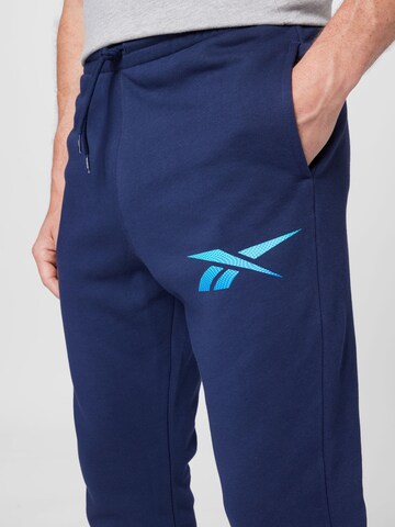 Reebok - Tapered Pantalón deportivo en azul