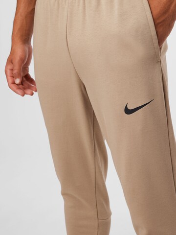 Effilé Pantalon de sport NIKE en beige