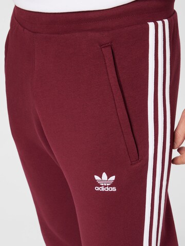 ADIDAS ORIGINALS Slimfit Housut 'Adicolor Classics' värissä punainen