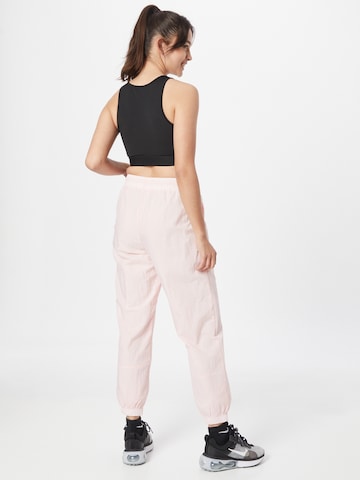 Nike Sportswear Zwężany krój Spodnie 'Essential' w kolorze różowy