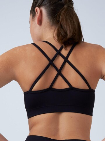 SPORTKIND Medium Support Sport-BH 'Crossed Straps'‌‌‌ in Schwarz