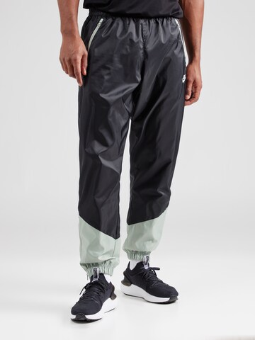 Nike Sportswear Tapered Trousers in Black: front