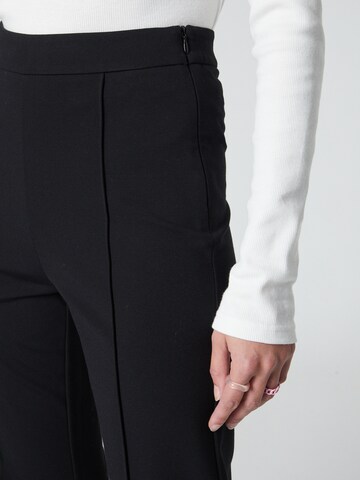 florence by mills exclusive for ABOUT YOU Flared Trousers 'Spruce' in Black