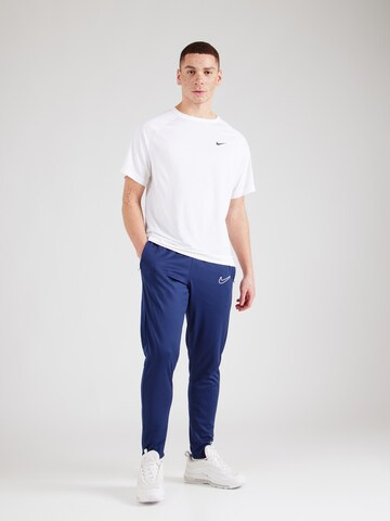 NIKE Tapered Urheiluhousut 'Academy 25' värissä sininen