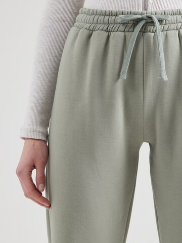 ABOUT YOU - Tapered Calças 'Laureen' em verde