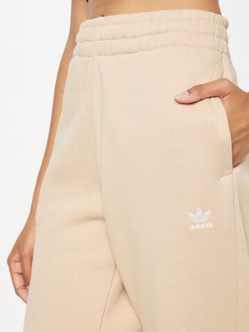 smėlio ADIDAS ORIGINALS Siaurėjantis Kelnės 'Adicolor Essentials Fleece'