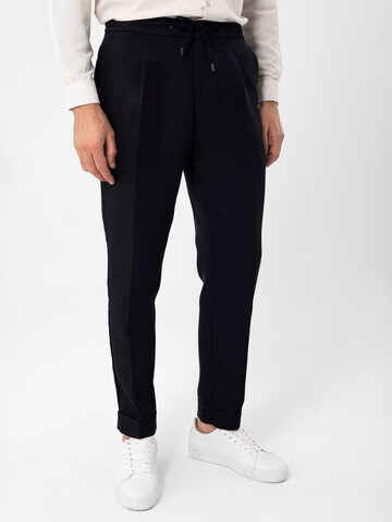 Antioch Tapered Pleat-Front Pants in Black: front