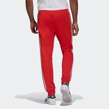 ADIDAS ORIGINALS Tapered Trousers 'Adicolor Classics Primeblue Sst' in Red