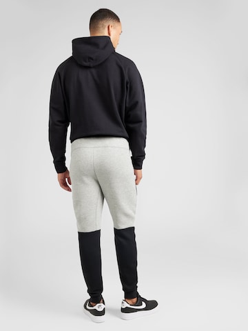 Nike Sportswear Tapered Byxa 'TECH FLEECE' i grå