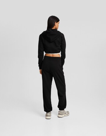 Bershka Tapered Byxa i svart