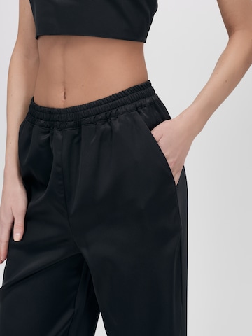 UNFOLLOWED x ABOUT YOU - Loosefit Pantalón 'Bossy' en negro