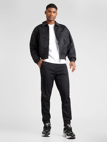 Sergio Tacchini Alt kitsenev Spordipüksid 'NEW DAMARINDO', värv must