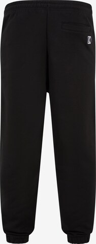 Karl Kani Tapered Pants in Black: front