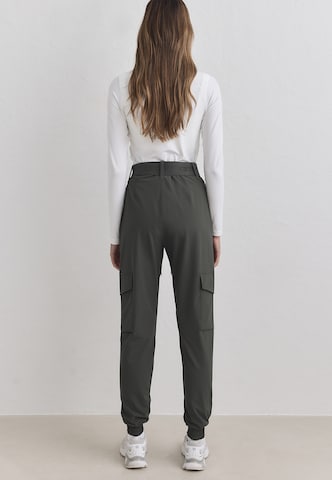 Tapered Pantaloni sportivi di Aim'n in verde