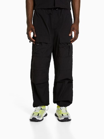 Bershka Loose fit Cargo trousers in Black: front