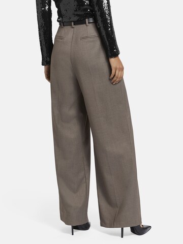 Nicowa Slimfit Anzughose 'ROSCIWO', weites Bein, Bundfalten, Model trägt Größe 34 in Braun