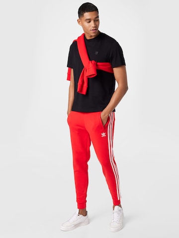 ADIDAS ORIGINALS - Tapered Calças em vermelho