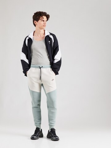 Tapered Pantaloni 'TCH FLC' de la Nike Sportswear pe verde