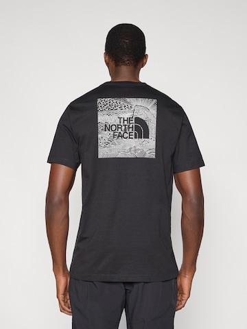 Tricou 'BOX NSE CELEBRATION' de la THE NORTH FACE pe negru: față