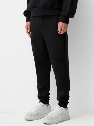 Bershka Tapered Bukser i sort: forside