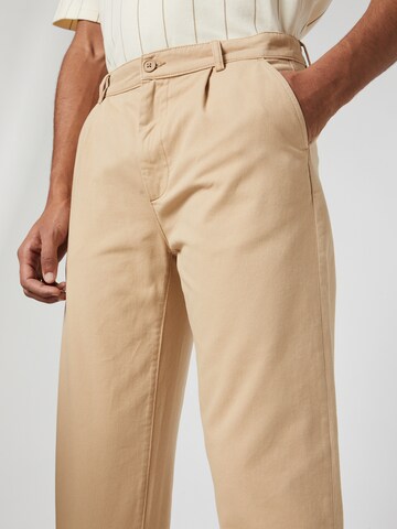 Kosta Williams x About You - regular Pantalón plisado en beige