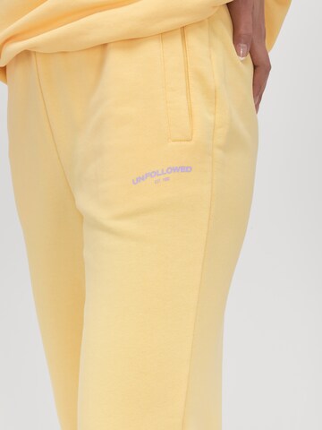 UNFOLLOWED x ABOUT YOU Zwężany krój Spodnie 'VIBE' w kolorze żółty